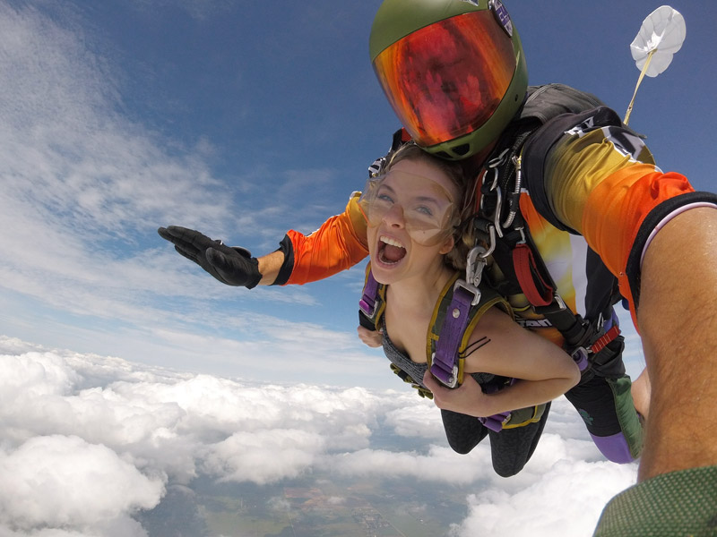 A tandem skydiver high above the clouds.